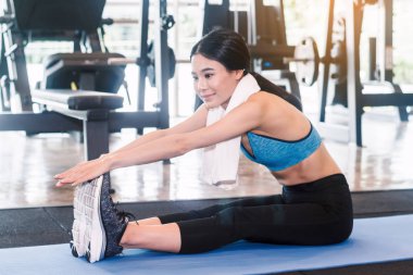 Fitness salonunda egzersiz ısınmak için kadın onun bacak Germe