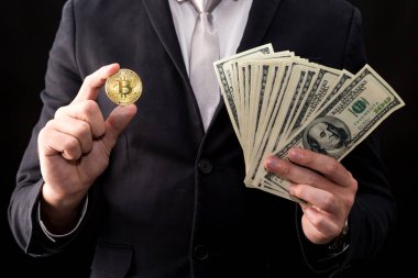 Bitcoin siyah arka planda tutan işadamı