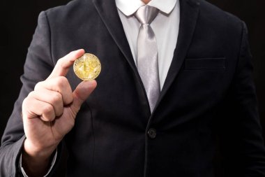 Bitcoin siyah arka planda tutan işadamı