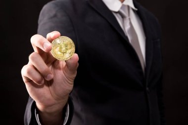 Bitcoin siyah arka planda tutan işadamı