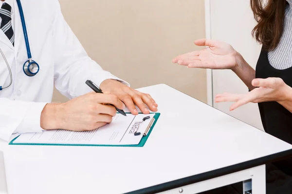 Ιατρική Γιατρός Ελέγχει Τις Πληροφορίες Γυναίκα Ασθενή Στο Τραπέζι Τους — Φωτογραφία Αρχείου