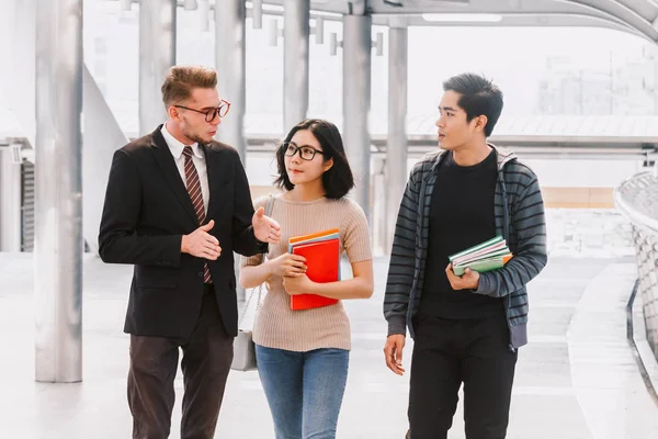 Lärare Med Två Studenter Håller Anteckningsböcker Utomhus Utbildning Konceptet — Stockfoto