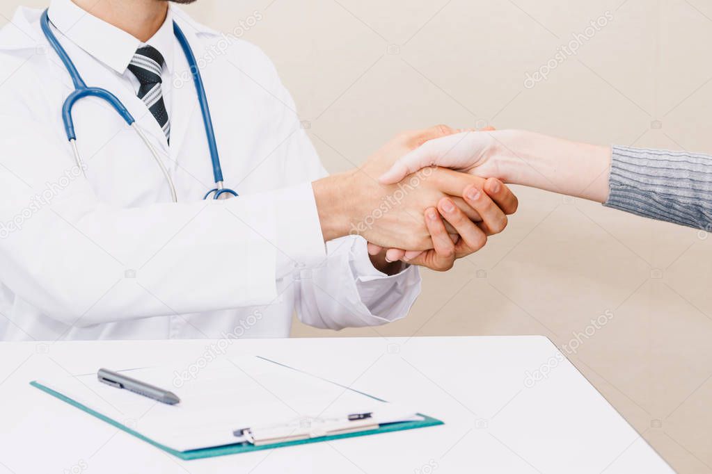 Doctor reassuring her female patient with care on doctors table in hospital.healthcare and medicine