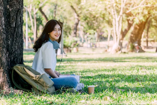 Kadın Sakin Park Çimenlerin Üzerinde Oturan Kulaklıklar Ile — Stok fotoğraf