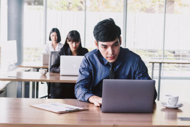 Dizüstü bilgisayar ve işletme belgesi üzerinde ofiste çalışan iş adamı