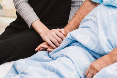 Genç kadın el yaşlı kişi elini tutuyor. Yaşlı Bakımı ve saygı kavramı