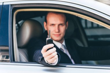 Takım elbiseli bir araba keys.dealership ve Kiralama kavramı veren işadamı