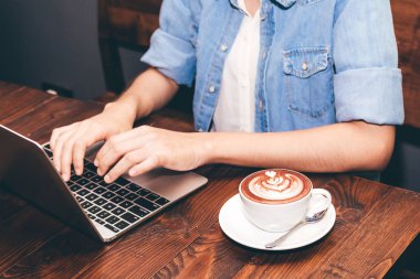 Kadın içme kahve ve kahve dükkanında dizüstü bilgisayarda çalışma