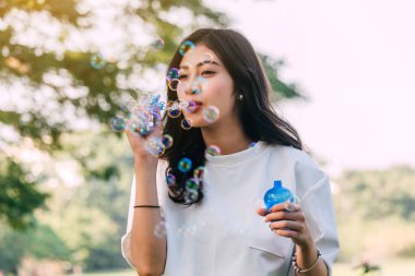 Güzel kadın yaz yeşil park adlı sabun köpüğü üfleme