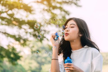 Güzel kadın yaz yeşil park adlı sabun köpüğü üfleme