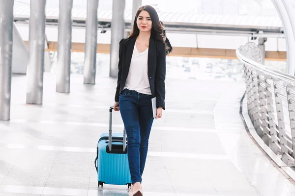 Happy successful businesswoman walking with luggage
