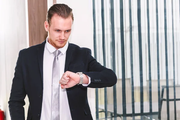 Businessman looking at watch at office building