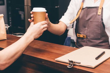 Müşteri kafede kahve fincanı veren kadın barista