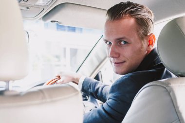 Bir arabada takım elbiseli yakışıklı işadamı