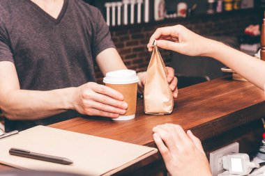 Müşteri kafede kahve fincanı veren kadın barista