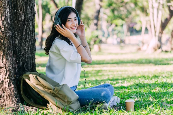 Kadın Sakin Park Çimenlerin Üzerinde Oturan Müzik Dinlerken Kulaklık Ile — Stok fotoğraf