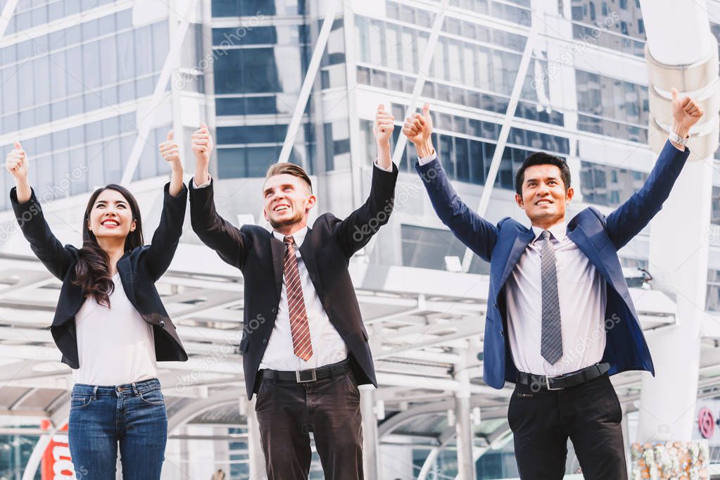 Successful business people celebrating with arms up
