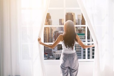 Uyanma ve pencere perdeleri evde açmayı kadın