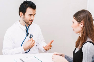 Doktor kadın hastayı hastanede muayene ediyor.