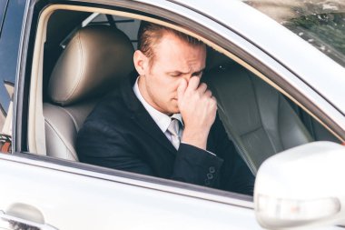 Bir arabada takım elbiseli yakışıklı işadamı