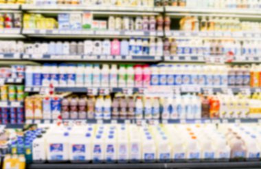 Taze süt şişeleri süpermarkette buzdolabı rafta satırın ufuk bulanıklık