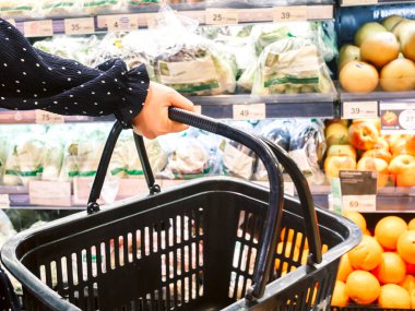 Boş alışveriş sepeti süpermarket raflarında organik taze sebze ile tutan kadın 