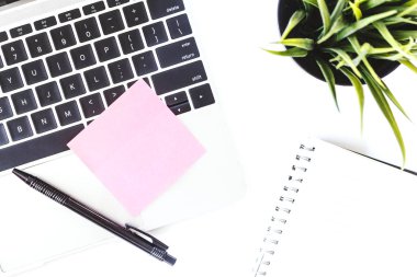 Dizüstü bilgisayar ve etiket Not görünümünü beyaz ofis resepsiyon masası üzerinde top. Düz yatıyordu