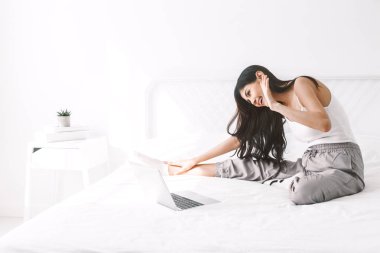 Yatak odasında dijital labtop bilgisayar kullanan kadın