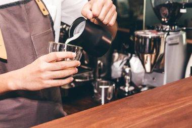 Barista kahve dükkanında yapmak kahve latte sanat için süt Holding'in