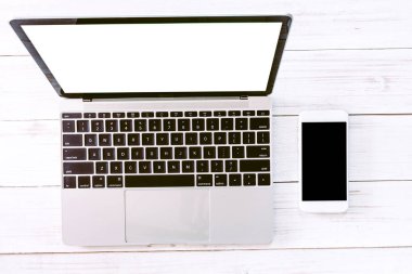 Beyaz ofis ahşap resepsiyon masası üzerinde en iyi görünümü ile boş perde smartphone ve dizüstü bilgisayar. Düz yatıyordu