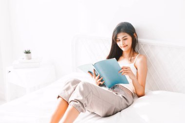 Kadın sabah yatakta kitap okuma
