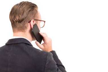 Beyaz arka plan üzerinde izole smartphone kullanarak zarif siyah elbiseli işadamı