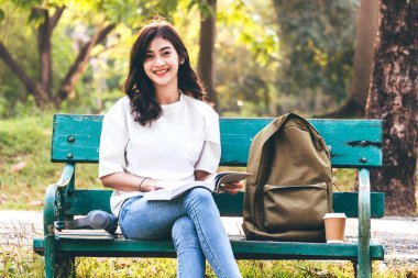 Kadın Öğrenciler defter açık havada okuma. Eğitim kavramı
