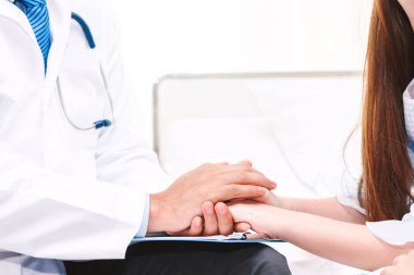 Doktor elini tutarak hospital.healthcare ve tıp doktorlar masada özenle küçük kız