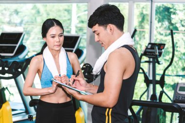 Gym.fitness ve yaşam tarzı kavramı yakışıklı eğitmen ve fitness kadına