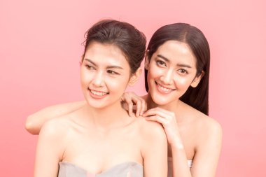 İki güzel kadın güzellik sağlık care.beauty ve spa.perfect taze cilt üzerinde pembe bir arka plan portresi
