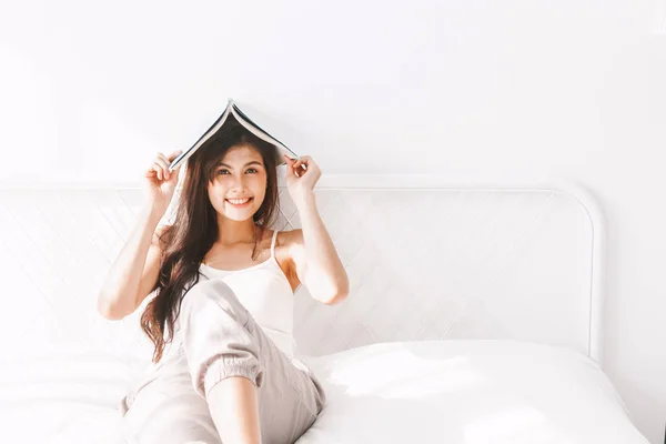 ベッドで本を持つ女性 — ストック写真