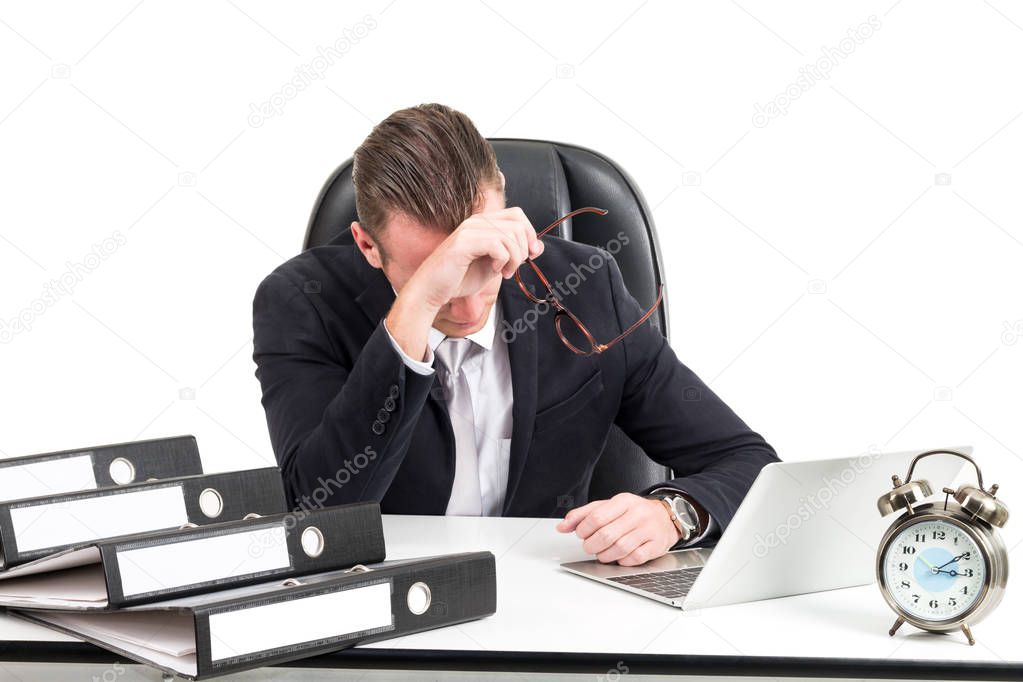 Businessman having problems and feeling headache while doing work at workplace, feeling tired exhausted isolated on white background