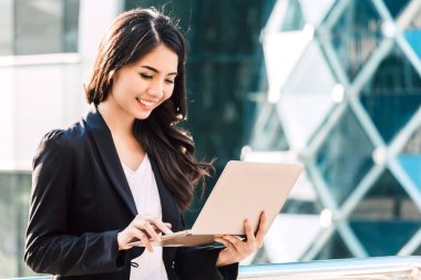 Dizüstü bilgisayar kullanan mutlu başarılı işkadını