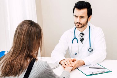 Doktor kadın hastasını özenle hospital.healthcare ve tıp doktorlar masada güven verici
