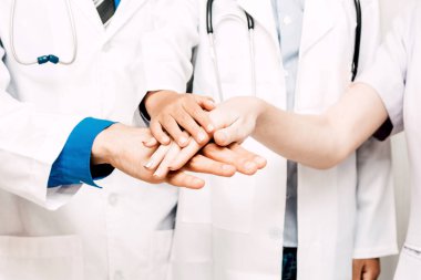 Group of successful doctors and nurses stack hands together at hospital