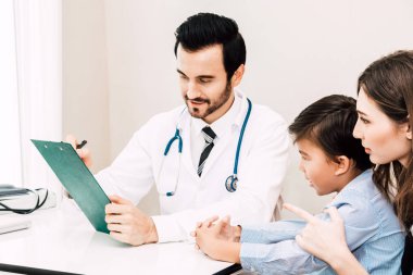 Doktor kontrol hospital.healthcare ve tıp doktorlar tabloda küçük çocuk ve anne ile bilgi