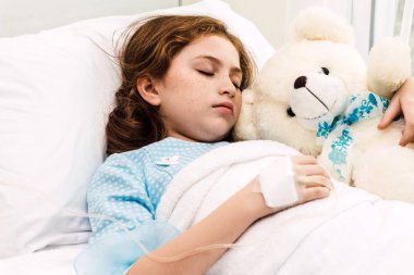 Hasta küçük kız yatakta ilaç yoluyla Intravenous hastanede yatıyor