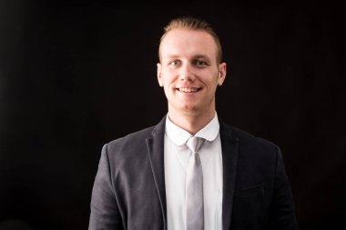 Yakışıklı işadamı izole siyah arka plan üzerine siyah takım elbise ile