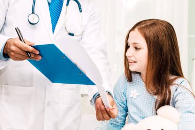 Danışmanlık doktor ve hastanede küçük kızla bilgilerini kontrol edin. Küçük bir kız sick.healthcare ve tıp vardır