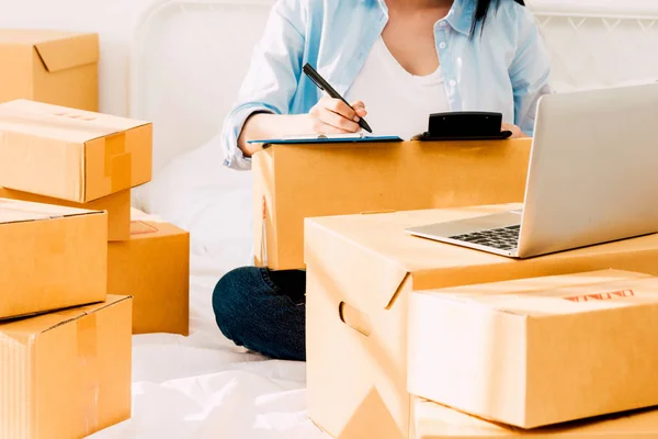 Mujer Joven Trabajando Lista Verificación Con Caja Cartón Cama Casa — Foto de Stock