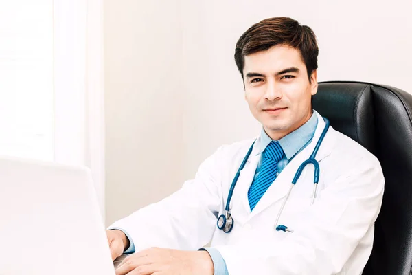 Médico Sonriendo Mirando Cámara Con Estetoscopio Trabajando Ordenador Portátil Hospital — Foto de Stock