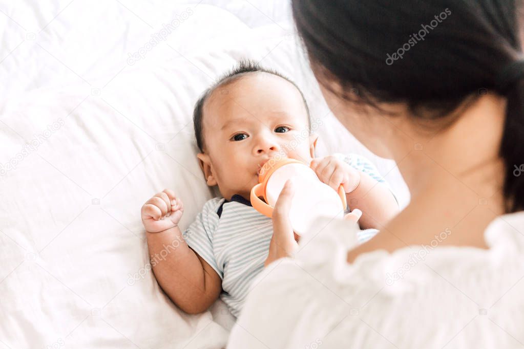 Mother feeding baby from milk bottle
