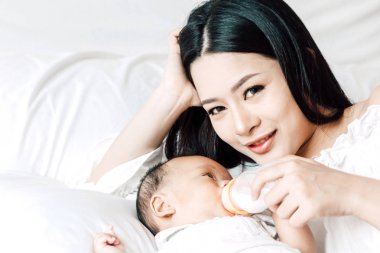 Yatakta çapa, süt şişe besleme bebek anne