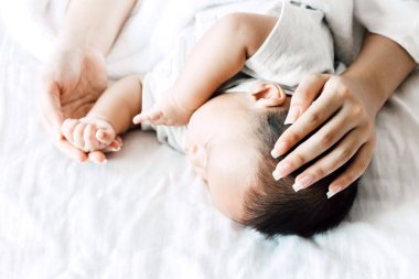 Bebek el Beyaz yatakta uyuyan anne holding. Aşk aile kavramının